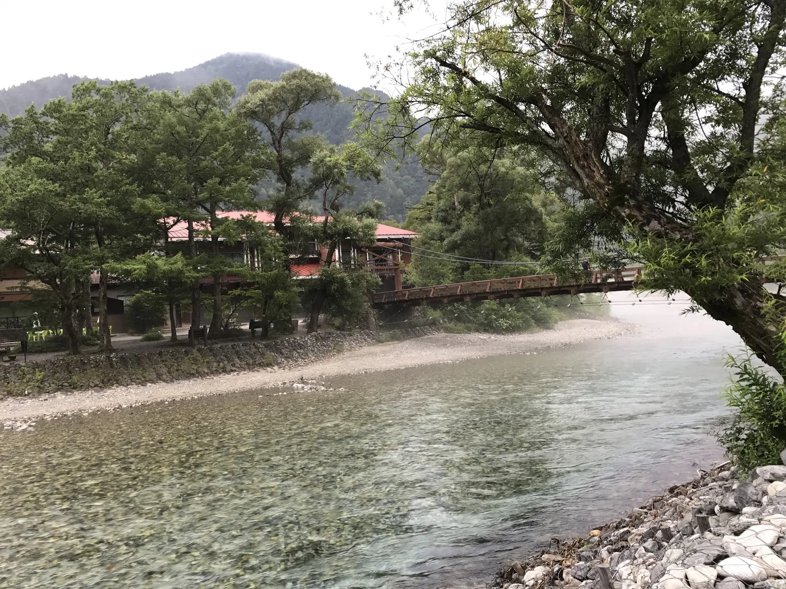 早朝の上高地・河童橋を岸から望む梓川の澄んだ流れと周囲の山並み