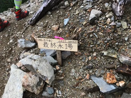 登山道脇に置かれた「(槍ヶ岳方面)最終水場 LAST WATER」と書かれた手書きの木の看板