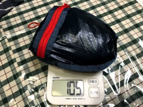 折りたたんだモンベル バーサライトパック15をキッチンスケールに乗せて計量し、105gと表示されている様子