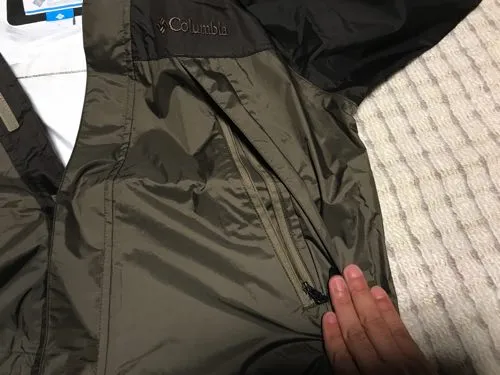 レインジャケットの前面にある脇のベンチレーション用ジップを指で開いて見せている写真