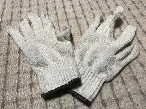 使用感のある綿の軍手が置かれている様子。初めての富士登山で防寒用に使ったもの