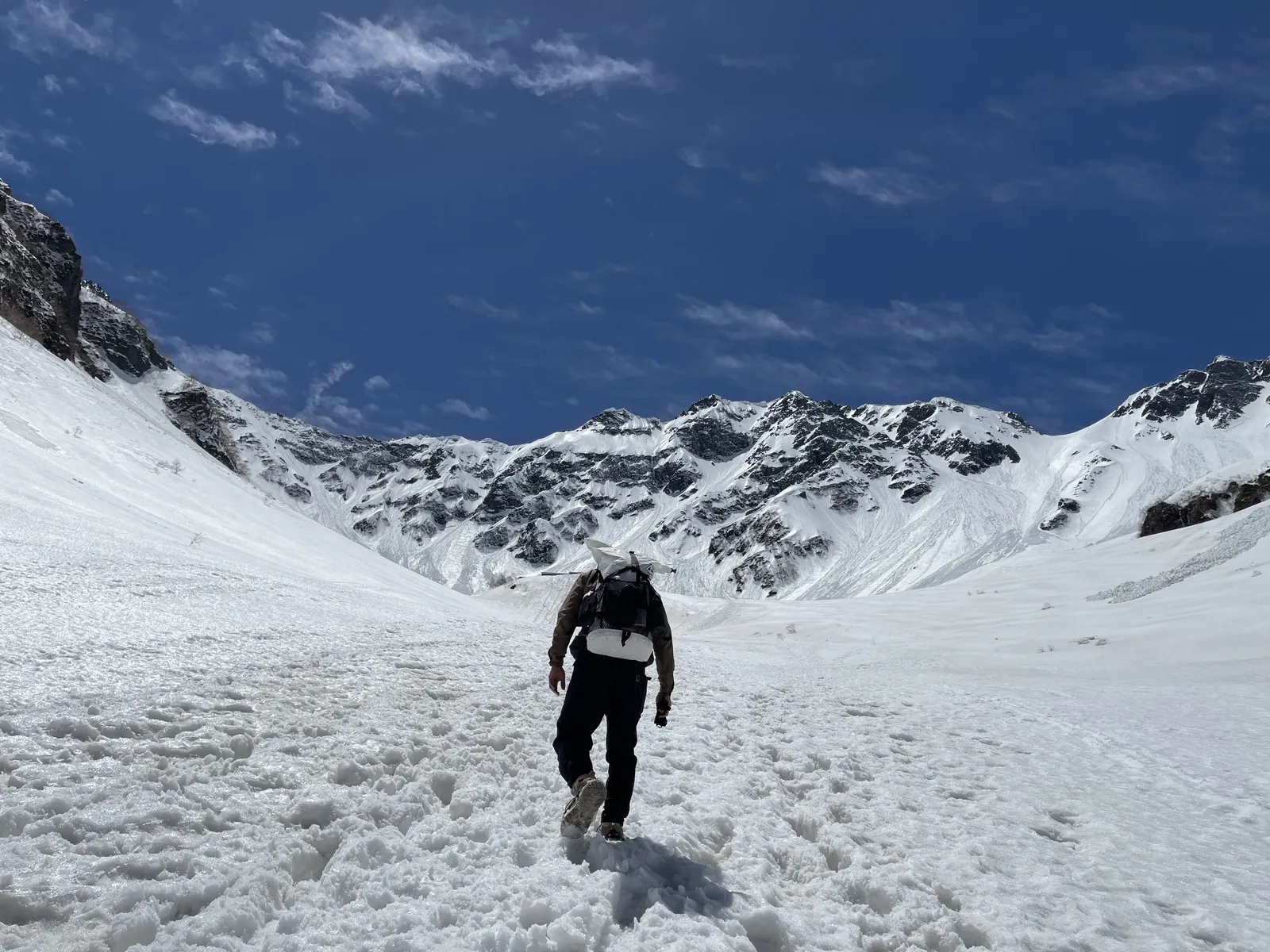 残雪期の涸沢へ向かう雪の斜面を登る登山者の後ろ姿